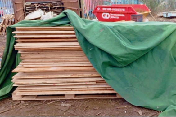 A stack of plywood covered with a green sheet